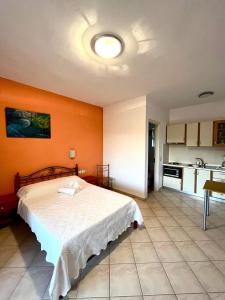 a bedroom with a bed and an orange wall at Emmanouil in Kythira