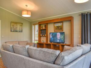 uma sala de estar com sofás e uma televisão de ecrã plano em Whitey Top Country Lodge em Pentridge