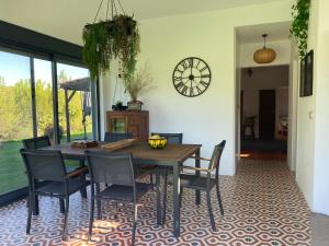 a dining room with a table and chairs and a clock at Monte da Marouca-Mont’Argil in Montargil