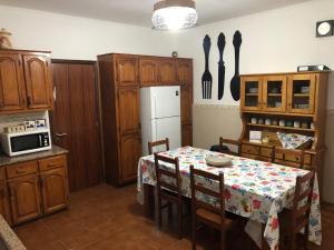 a kitchen with a table and a white refrigerator at Quinta do Avô Dimas - Rural Home - São Brás in Porto Formoso
