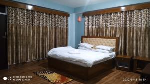 a bedroom with a bed in a room with curtains at Mandavya homestay in Pelling