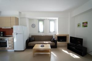 a living room with a couch and a white refrigerator at Aetofolia Villa in Fourka