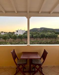 a table and two chairs in front of a large window at Emmanouil in Kythira