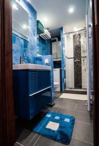 niebieska łazienka z umywalką i prysznicem w obiekcie AM-Residence No. 19 w Wiedniu