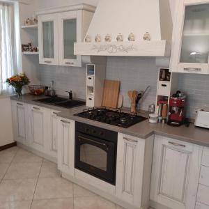 薩羅的住宿－Appartamento GIRASOLE, Salò，厨房配有白色橱柜和炉灶烤箱。