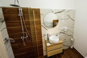 La salle de bains est pourvue d'un lavabo et d'un miroir. dans l'établissement Pensiunea Maya Caciulata, à Căciulata