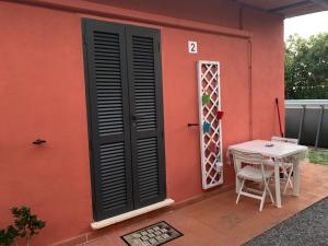 a red house with a table and a window at Camera graziosa in Albinia