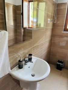 y baño con lavabo blanco y espejo. en Thethi view, en Gjelaj