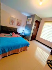 um quarto com uma cama com um bicho de peluche em UNO'S Place with Karaoke,Wifi,Netflix and Balcony em Anabu Primero