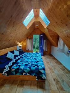 - une chambre mansardée avec un grand lit dans l'établissement Last Stop Riverside wooden Huts, Camps & Dorms, à Manali