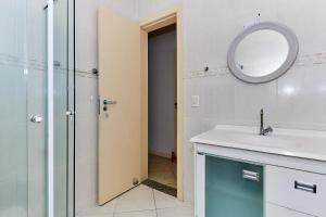 ein Badezimmer mit Waschbecken, Spiegel und Dusche in der Unterkunft 791 - Cobertura com piscina. 200m da PRAIA. BOMBINHAS - CENTRO in Bombinhas + 31 Fotos