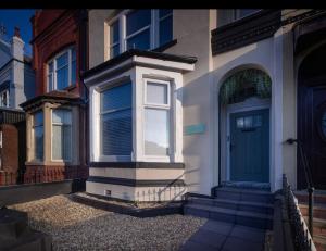 a house with a blue door on a street at Coral Boutique Apartment 2 in Blackpool