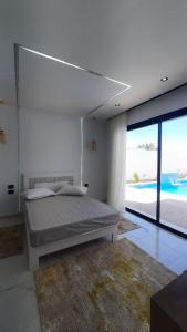 a bedroom with a bed and a view of the ocean at Villa de luxe sans vis-à-vis à 2 min de la plage in Djerba