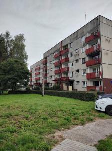an apartment building with a car parked in front of it at Apartament Czeladź 60m2 Centrum Katowic 10km in Czeladź