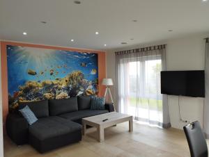 una sala de estar con sofá y una pintura de pescado en RK Apartments Birnbaum en Gerhardshofen