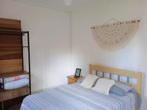 um quarto com uma cama com duas almofadas em Terral Casa de Praia no Guarujá