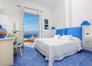 a bedroom with a bed and a desk and a window at Relais Maresca Luxury Small Hotel & Terrace Restaurant in Capri