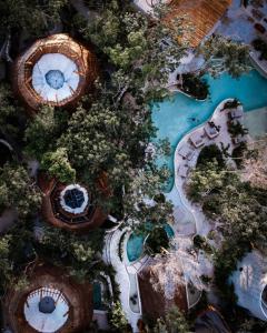 einen Blick über den Pool in einem Themenpark in der Unterkunft Hotel Muaré & Spa Tulum in Tulum