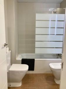 a bathroom with a toilet and a bath tub at Apartamento centro con parking privado in Zaragoza