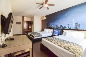 a hotel room with two beds and a flat screen tv at Hotel Tötem Guadalajara in Guadalajara +16 photos