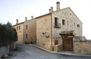 an old stone building with a gate on a street at Hotel Rural La Data in Gallegos