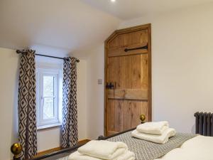 a bedroom with a wooden door and two towels on a bed at Middle Hanter - Uk37355 in Old Radnor