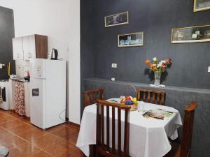 cocina con mesa y nevera blanca en Apartamentos Victoria en Asunción