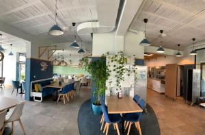 a dining room with tables and blue chairs at Apartamenty z basenem in Sarbinowo