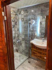 y baño con ducha y lavamanos. en Muzepotamia Butik Otel en Sanlıurfa