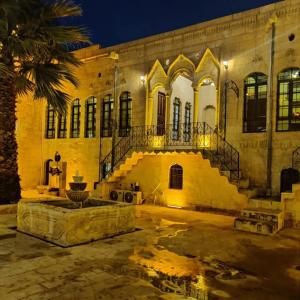 a building with a staircase in front of it at night at Muzepotamia Butik Otel in Sanlıurfa