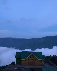 un edificio con techo verde en la cima de una montaña en Raibas Homestay, en Darjeeling