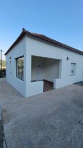 een wit huis met een grote garage bij Casinha da Belavista in Arcos de Valdevez +9 foto's