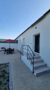 ein Gebäude mit einer Treppe und einer Terrasse mit einem Tisch in der Unterkunft Casinha da Belavista in Arcos de Valdevez