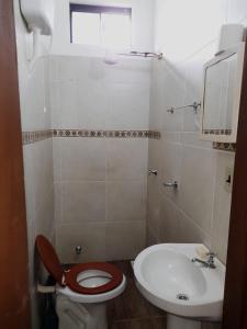 y baño con aseo y lavamanos. en Apartamentos Victoria, en Asunción