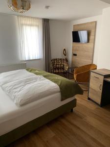 Schlafzimmer mit einem Bett, einem Schreibtisch und einem Stuhl in der Unterkunft Hotel Haus Burg Metternich in Beilstein