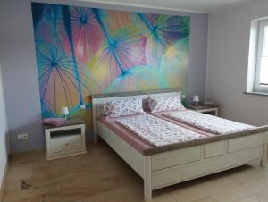 1 dormitorio con 1 cama con una pintura en la pared en RK Apartments Birnbaum en Gerhardshofen