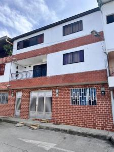 a red and white brick building with many windows at Acogedor apto en Sonsón in Sonsón