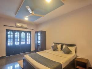 a bedroom with a bed and a ceiling fan at Calangute Beach Corner in Calangute