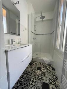 La salle de bains blanche est pourvue d'une douche et d'un lavabo. dans l'établissement Centre Ville Superbe T2 Neuf Wifi Terrasse Netflix, à Périgueux