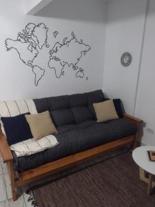 a living room with a couch with a world map on the wall at Departamento vista al mar Playa Las Toscas in Mar del Plata