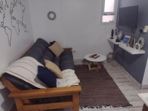 uma sala de estar com um sofá e uma mesa em Departamento vista al mar Playa Las Toscas em Mar del Plata