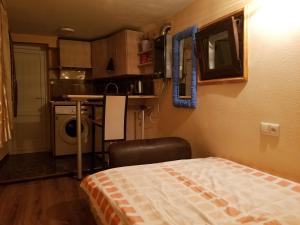 a small room with a bed and a kitchen at Silk House in Tbilisi City