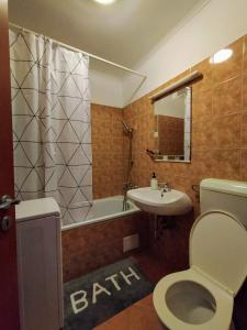 uma casa de banho com um WC, um lavatório e uma banheira em Spacious apartment in hip neighborhood em Budapeste