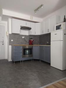 uma cozinha com armários brancos e um forno com placa de fogão em Spacious apartment in hip neighborhood em Budapeste