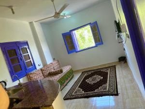 uma sala de estar com um sofá, uma mesa e uma janela em Ghalia Guest House em Aswan