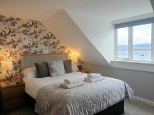 um quarto com uma cama com toalhas em Carnaburg Guesthouse em Tobermory