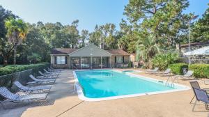 a swimming pool with chairs and a house at Spacious Cozy Condo! Perfect for longer stays in Mobile