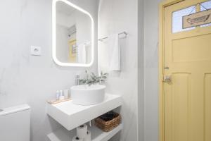 a white bathroom with a sink and a mirror at São Miguel Apartments in Porto +40 photos