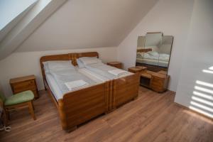 a bedroom with a bed with a mirror and a chair at Reneszánsz Vendégház in Debrecen