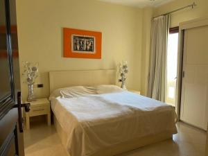 sypialnia z białym łóżkiem i oknem w obiekcie Gravity Joy Apartments Sahl Hasheesh w mieście Hurghada
